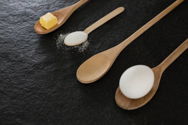 Cucharas de madera con huevo, cubo de queso —  Fotos de Stock