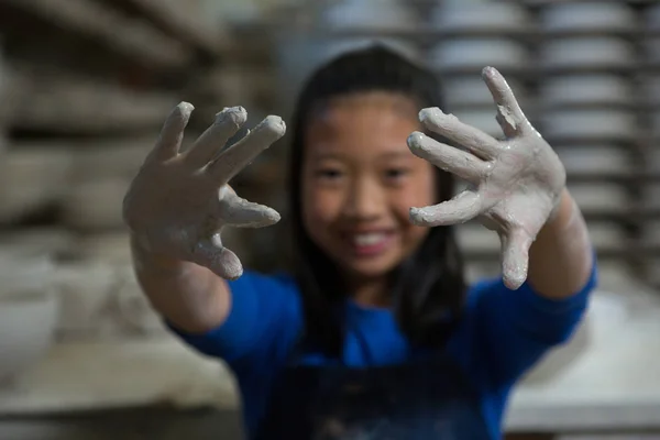 Onnellinen tyttö näyttää mutainen kädet — kuvapankkivalokuva