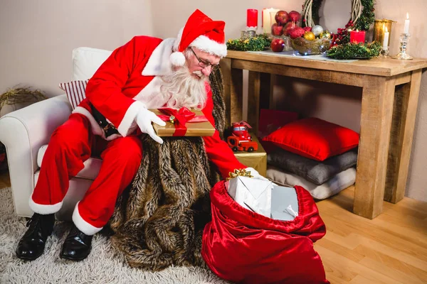 Weihnachtsmann schläft am Tisch, während er einen Brief mit einem Federkiel schreibt — Stockfoto