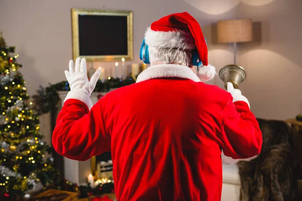 圣诞老人在耳机上听音乐 — 图库照片