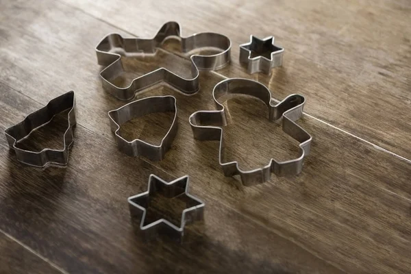 Various cookie cutters on wooden table — Stock Photo, Image