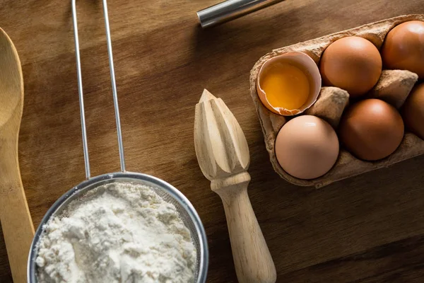 Mehl, Eier und Löffel auf den Tisch — Stockfoto
