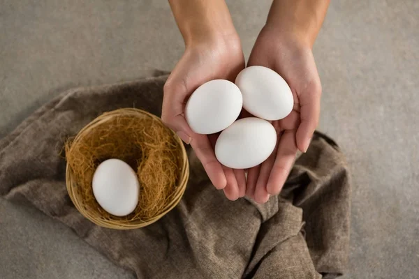 Mujer sosteniendo huevos blancos —  Fotos de Stock