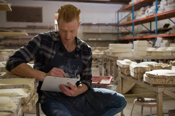 Mannelijke potter schrijven op een Klembord — Stockfoto