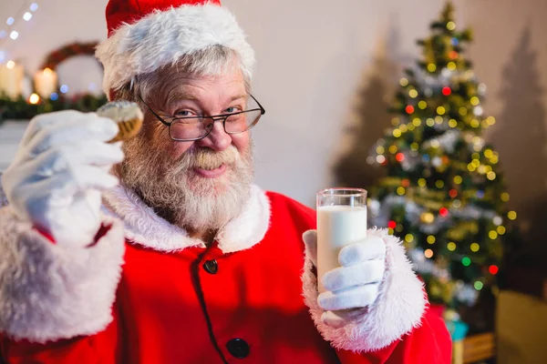Santa Claus having a cookie with milk — Stock Photo, Image