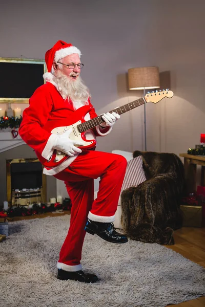 Lächelnder Weihnachtsmann, der Gitarre spielt — Stockfoto