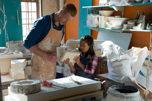 Male potter and girl selecting slab — Stock Photo, Image