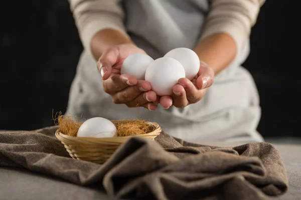 Mujer sosteniendo huevos blancos —  Fotos de Stock