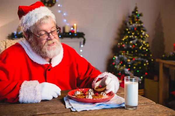 Weihnachtsmann mit Plätzchen und einem Glas Milch — Stockfoto