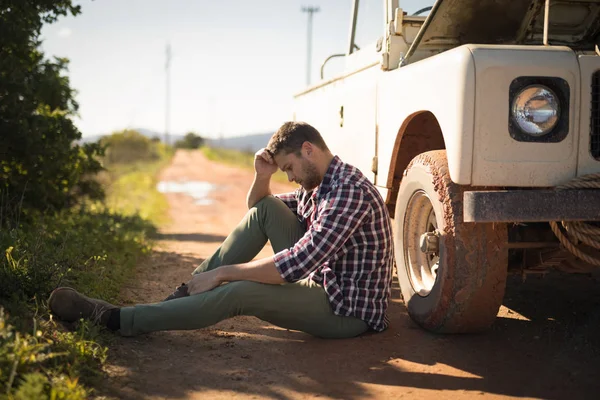 Uomo depresso seduto vicino a una macchina — Foto Stock