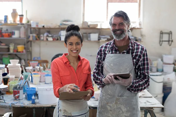Male and female potter standing in workshop — Stock Photo, Image