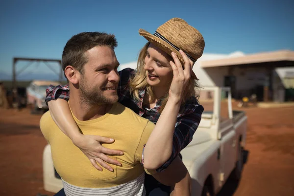 Man giving a piggyback ride to woman — Stock Photo, Image