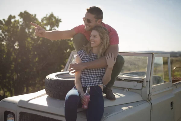 Par med drycker på motorhuven av bil — Stockfoto