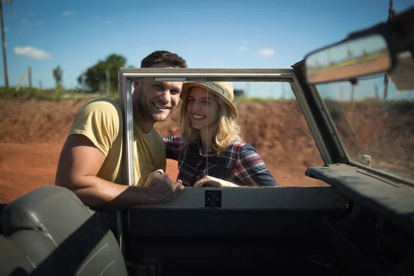 Pareja romancing juntos detrás de un coche —  Fotos de Stock