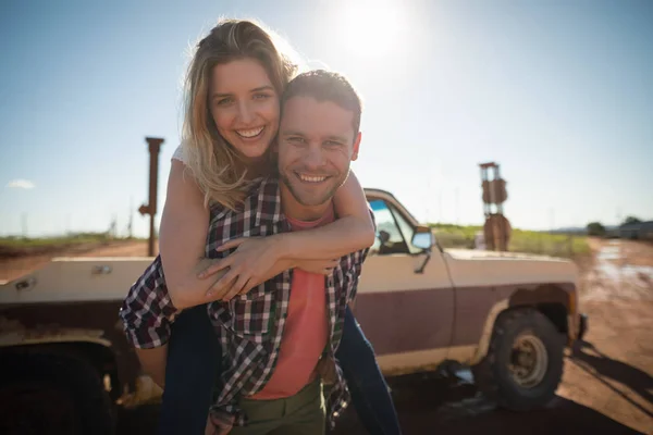 Uomo dando un giro a cavalluccio alla donna — Foto Stock