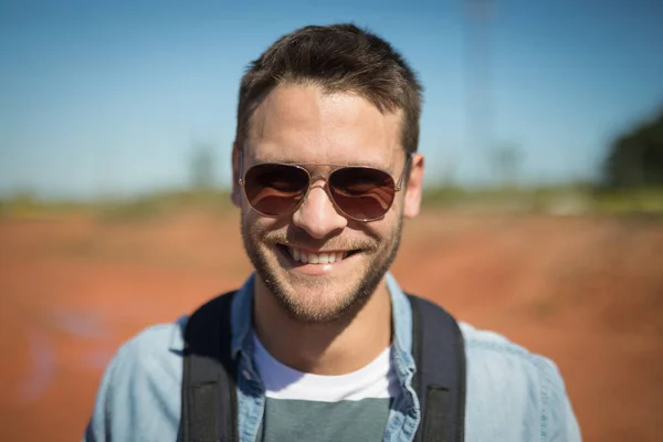 Homem de óculos de sol de pé com sua mochila — Fotografia de Stock