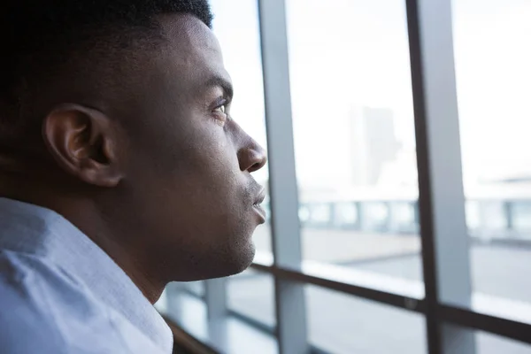 Homme regardant par la fenêtre dans le bureau futuriste — Photo