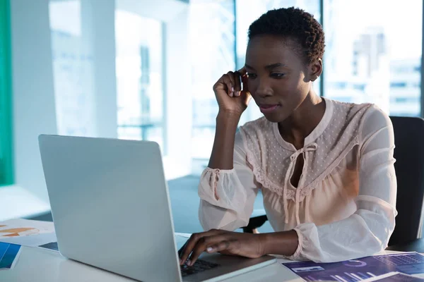 Ejecutivo femenino usando portátil en el escritorio — Foto de Stock