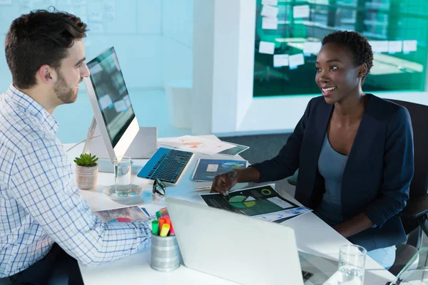 Führungskräfte interagieren am Schreibtisch miteinander — Stockfoto