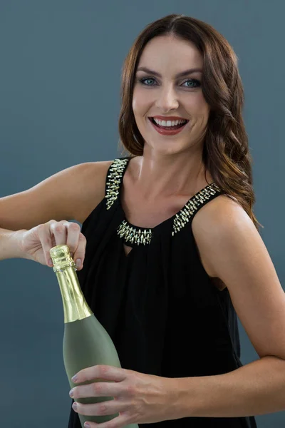 Vrouw opening fles champagne — Stockfoto