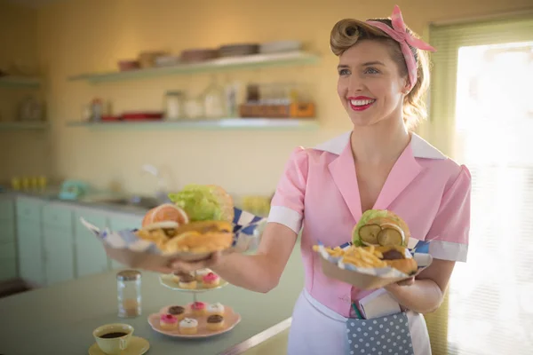 Waitress holding plate of meals in restaurant — Stock Photo, Image