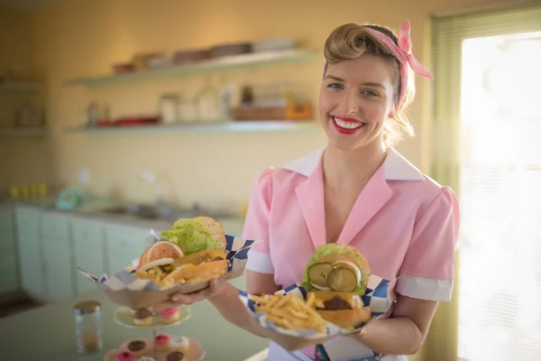 Waitress holding plate of meals in restaurant — Stock Photo, Image