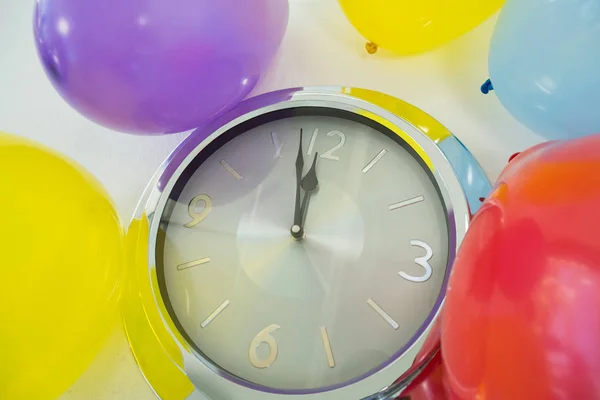 Globos y manecillas de reloj llegando a las 12 en punto —  Fotos de Stock