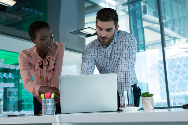 Führungskräfte diskutieren am Schreibtisch über Laptop — Stockfoto