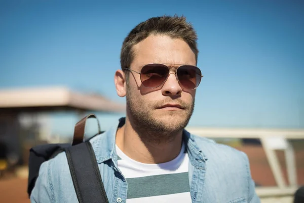 Man in sunglasses standing with backpack — Stock Photo, Image