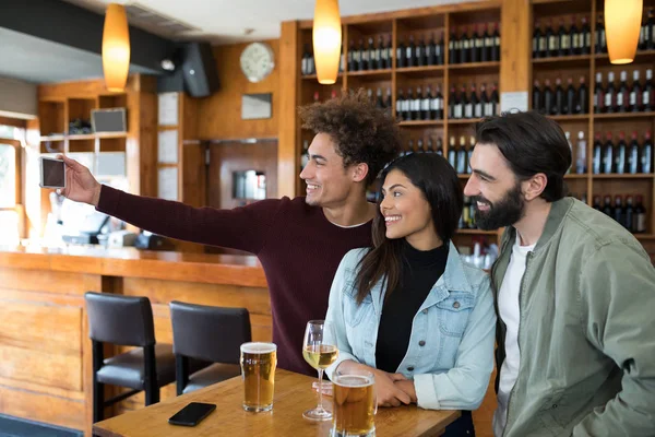 Vrienden nemen selfie met mobiele telefoon — Stockfoto