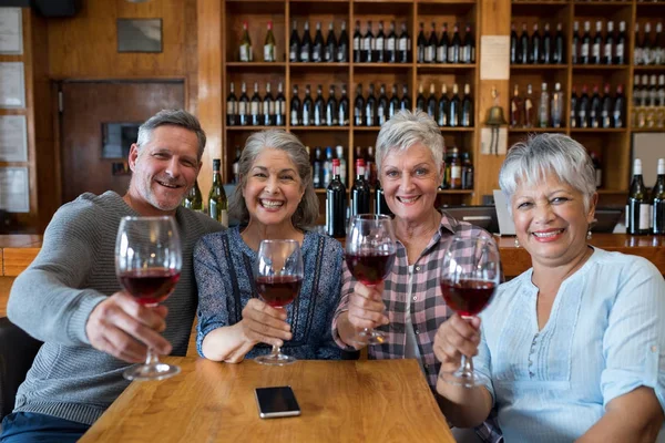 Senior przyjaciółmi o czerwone wino w restauracji — Zdjęcie stockowe