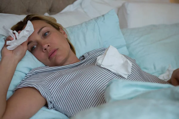 Mujer enferma acostada en la cama — Foto de Stock