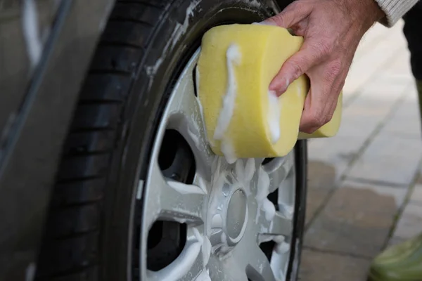 Auto serviço pessoal lavar um pneu de carro — Fotografia de Stock