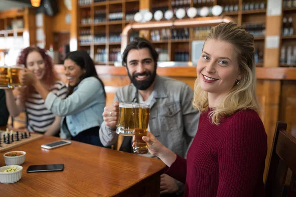 ビールのグラスを乾杯の友人のバー — ストック写真