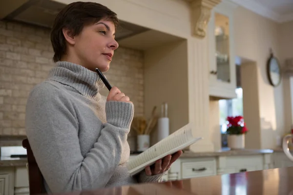 Beautiful woman writing in organizer — Stock Photo, Image