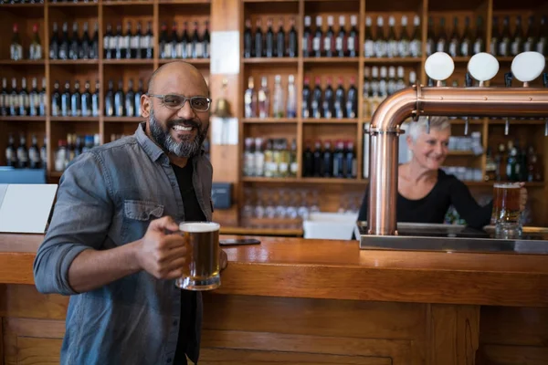 Homme souriant prenant un verre de bière au restaurant — Photo