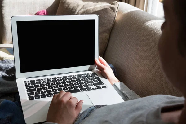 Frau benutzt Laptop auf Sofa — Stockfoto