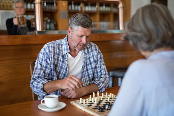 Friends playing chess while having coffee — Stock Photo, Image