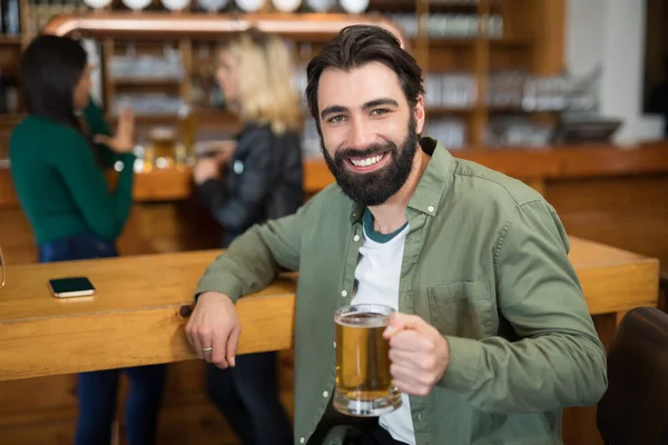 Homme tenant un verre de bière dans le bar — Photo