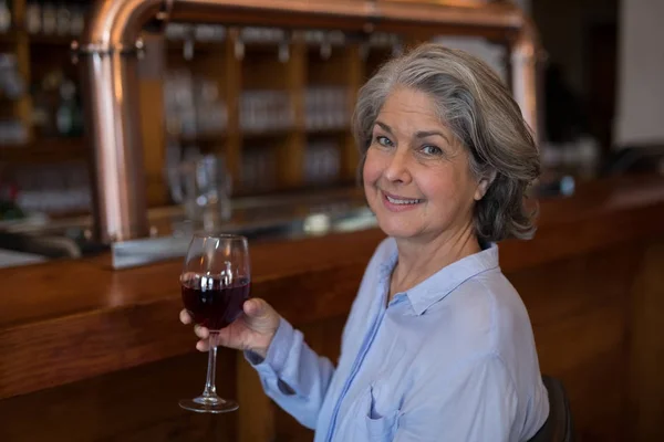 Ανώτερος γυναίκα έχοντας ποτήρι κόκκινο κρασί — Φωτογραφία Αρχείου