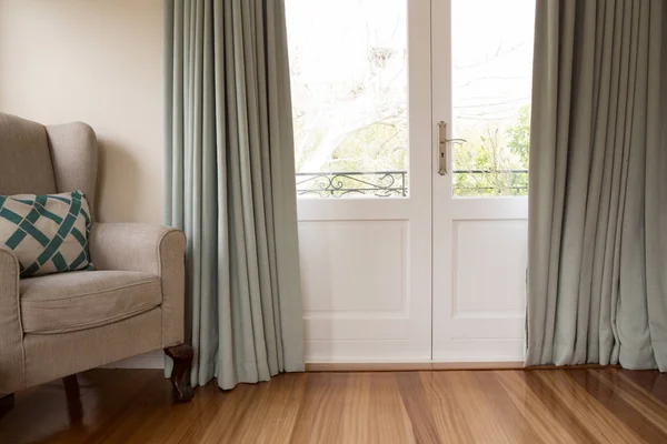 Closed door with sofa on wooden floor — Stock Photo, Image