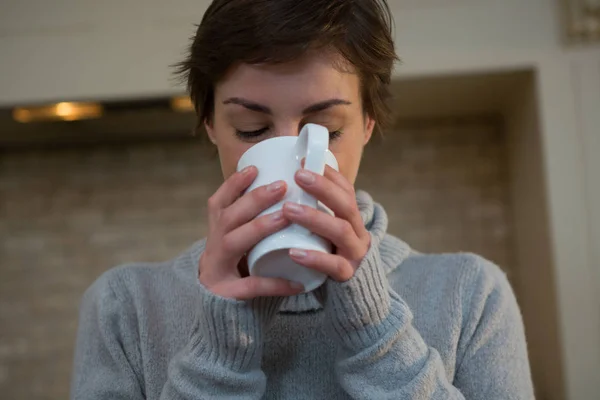 Kvinna med kopp kaffe i köket — Stockfoto