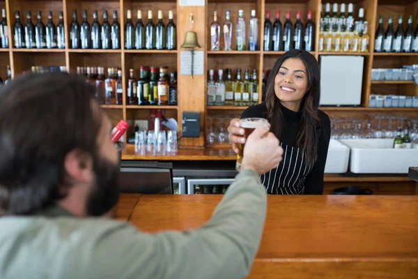 Camarera sirviendo vaso de cerveza al cliente — Foto de Stock