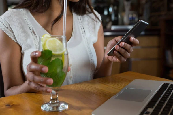 Žena používající mobilní telefon na baru — Stock fotografie