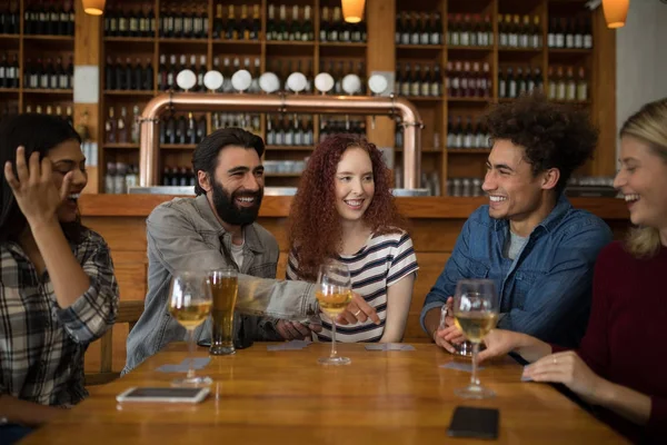 Vrienden interactie terwijl het hebben van glas bier — Stockfoto