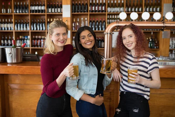 Female friends having glass of beer at counter — Stock Photo, Image