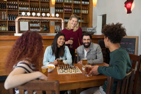 Vrienden interactie terwijl het hebben van glas bier — Stockfoto