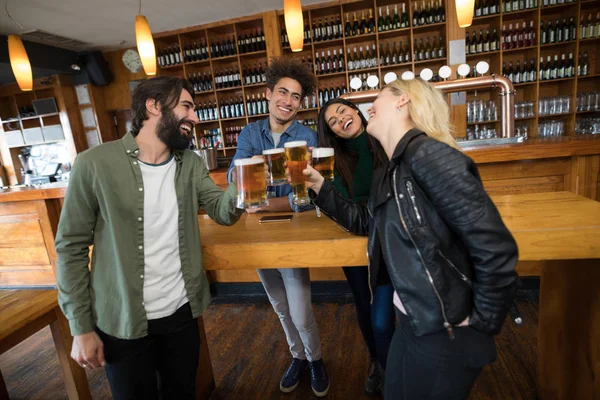 Vrienden roosteren glas bier in staaf — Stockfoto
