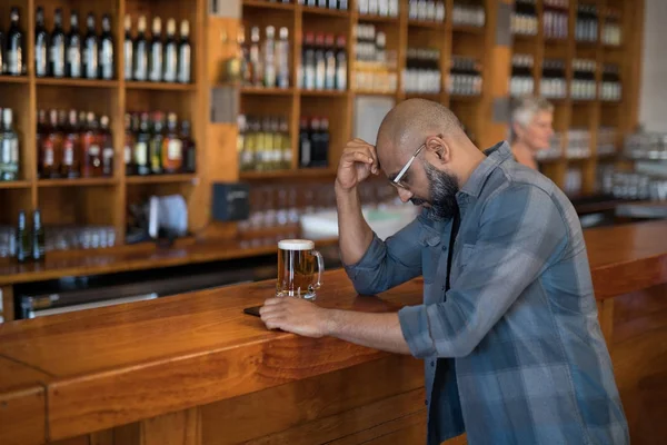 Depressed man standing at counter — Stock Photo, Image