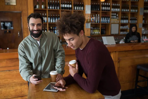 Due amici maschi utilizzando il telefono cellulare — Foto Stock